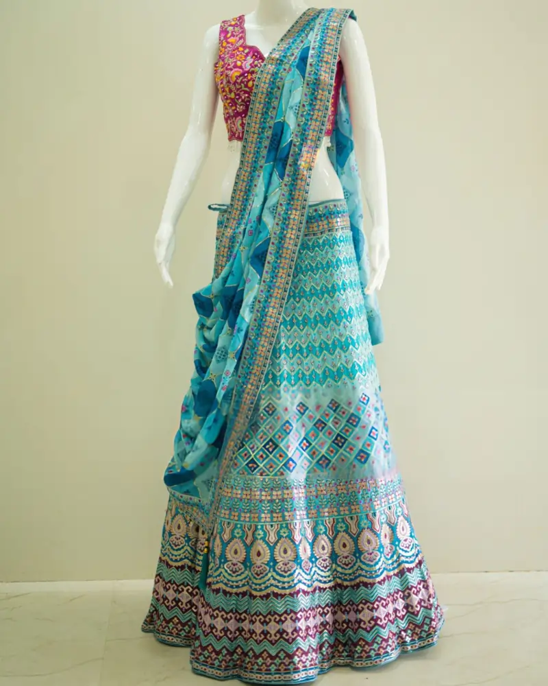 Turquoise embroidered lehenga choli with magenta blouse and blue dupatta for traditional wear.