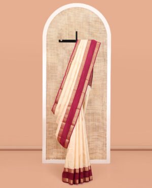Cream Vasundhara Silk Saree, Steeped In Richness Of Zari Buttas All Over Its Body, Complemented By A Contrast Rettai Pettu Border Of Rekku, Muthu, And Chakram Designs, Grand Pallu, And Paired With A Contrast Blouse