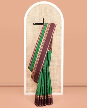 Green Vasundhara Silk Saree, Elevated With Zari Buttas All Over Its Body, Complemented By A Contrast Rettai Pettu Border Of Yaanai Designs, Grand Jaal Pallu, And Paired With A Contrast Blouse
