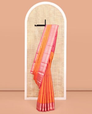 Orange Vasundhara Silk Saree, Sparsely Sparkled With Zari Buttas All Over Its Body, Complemented By A Contrast Border Of Rekku, Muthu, Kili, Banaras, Neli, And Mayil Kann Designs, Grand Pallu, And Paired With A Contrast Blouse