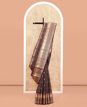 Brown Vasundhara Silk Saree, Masterfully Woven With Zari Buttas And Checks All Over Its Body, Highlighted By  Zari Border Of Rekku, Muthu, Kathir, Mayil, Neli, And Manga Designs, Grand Pallu, And Paired With A Contrast Blouse